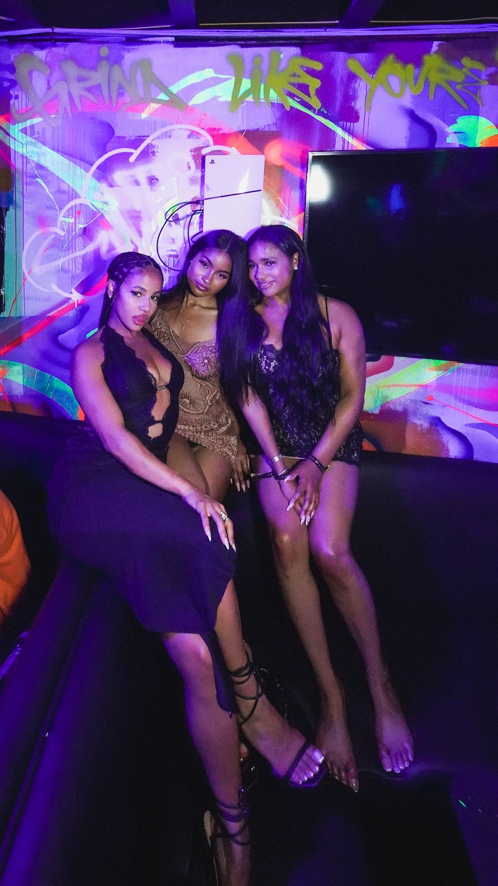Group seated in a VIP booth by the neon graffiti wall